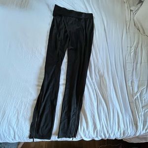 Black leggings with elastic waistband and zippers at ankles